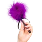 Preview: Hand holding purple feather duster with black handle.