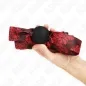 Preview: Hand holds a red ball gag with a black ball and patterned band.
