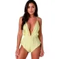 Preview: Woman in a yellow, low-cut jumpsuit with spaghetti straps against a white background.