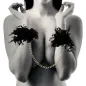 Preview: Woman wearing black feather handcuffs and a gold chain, arms crossed in front of her chest.