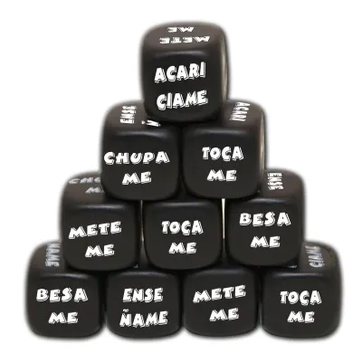 Schwarze Würfel mit spanischen Aufforderungen wie "Toca me" und "Besa me" in einer Pyramide gestapelt.