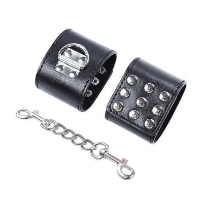 Schwarze Lederhandfesseln mit silbernen Nieten und Kette mit Karabinerhaken.