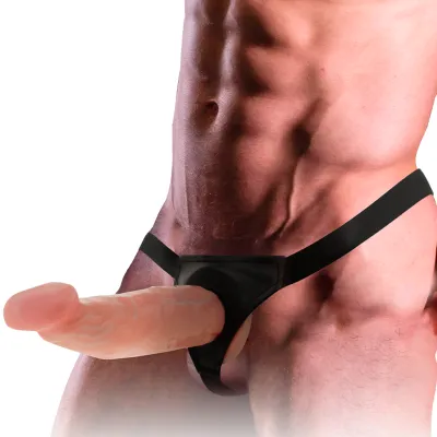 Mann mit muskulösem Oberkörper trägt einen schwarzen Strap-on-Gürtel mit einem großen, realistisch aussehenden Dildo.
