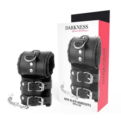 Schwarze, breite Handschellen mit Fell und Kette, neben einer Verpackung mit der Aufschrift "Darkness".