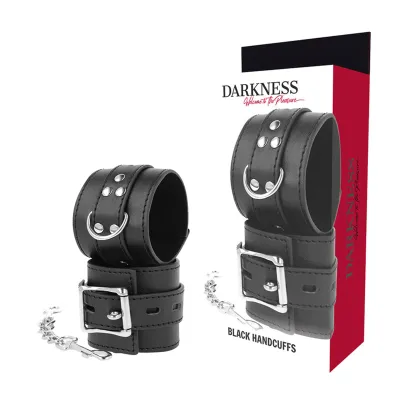 Black leather handcuffs with metal clasps and chain, packaged in a box labeled "Darkness".