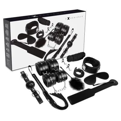 Schwarzes Bondage-Set mit Fesseln, Augenbinde, Ballknebel, Peitsche und weiteren Accessoires vor Verpackung.