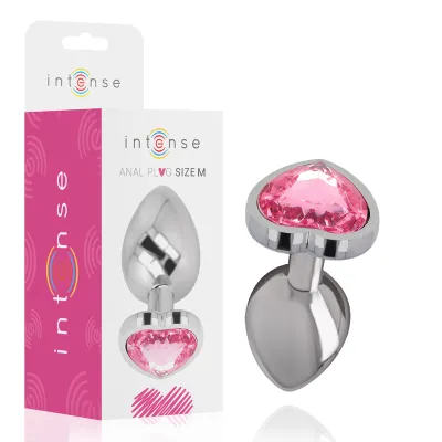 Silver anal plug with pink heart-shaped stone, packaging in the background.