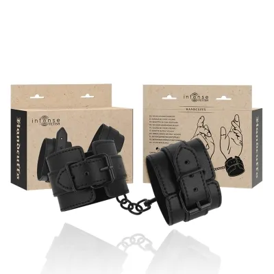 Black vegan leather handcuffs with packaging in the background, illustrated with hands.