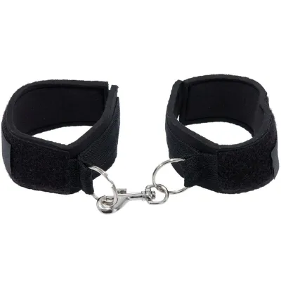 Schwarze Handfesseln mit Klettverschluss und Metallhaken, verbunden durch einen Ring.