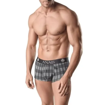 Mann in karierten Boxershorts mit muskulösem Oberkörper, steht vor weißem Hintergrund.