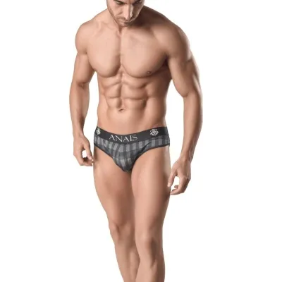 Mann in karierten Boxershorts mit "ANAIS"-Aufdruck, muskulös, schaut nach unten, vor weißem Hintergrund.