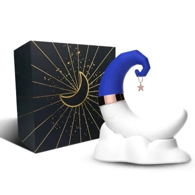 Moon-shaped sculpture with a blue hat and star pendant, next to it a black box with a golden moon graphic.