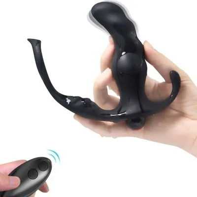 Black, curved massage device with remote control, held in one hand.