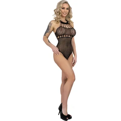 Woman in black mesh bodysuit and high heels, smiling, with curly hair and a tattoo on her arm.
