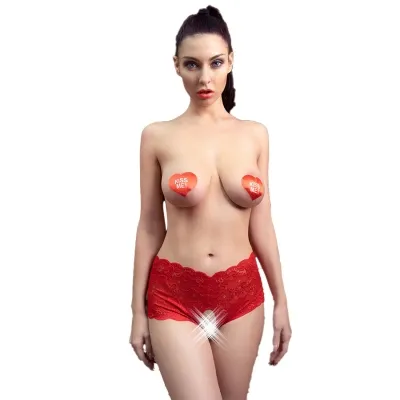 Frau in roter Spitzenunterwäsche mit Herzaufklebern auf der Brust, die "Kiss Me!" sagen.