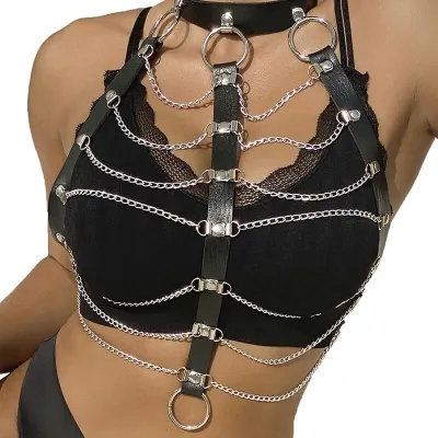 Woman wears black leather and chain harness over black top.