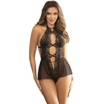 Woman in black lace lingerie with transparent details, smiling and standing against a white background.