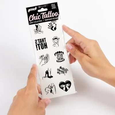Hände halten ein Set temporärer Tattoos mit verschiedenen Designs und Texten wie "THAT'S HOT!" und "BITE HERE".