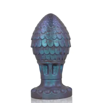 Blue-purple sculpture with a scale-like surface and wide base, reminiscent of a pine cone.