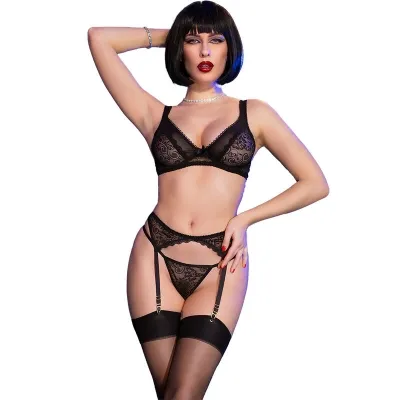 Woman in black lace lingerie with garter belt and pearl necklace, posing in front of a white background.