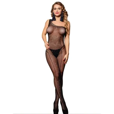 Woman in black mesh bodysuit with rhinestones, wearing black underwear and earrings, posing in front of a white background.