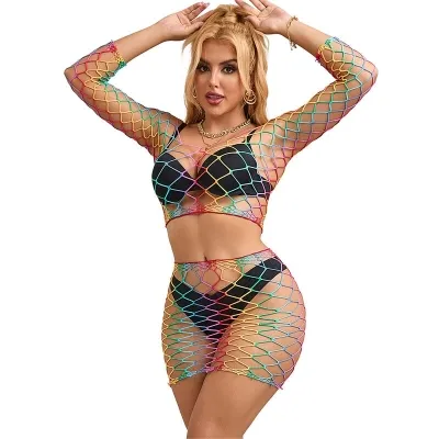 Woman in a colorful mesh dress over black underwear, posing with raised arms.
