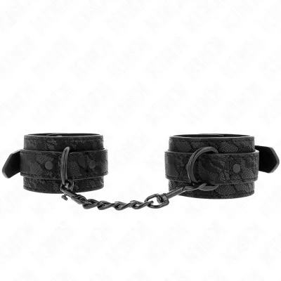 Schwarze Handfesseln mit Kette, aus Lederimitat mit Spitzenmuster, auf weißem Hintergrund.