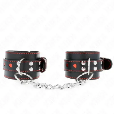 Schwarze Lederhandschellen mit roten Nähten und Herzdetails, verbunden durch eine Metallkette.