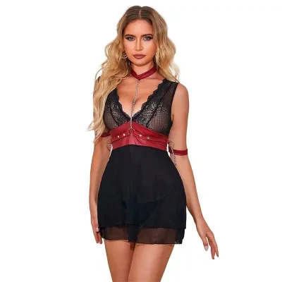 Woman in black lace dress with red leather harness and chain, blonde hair, white background.