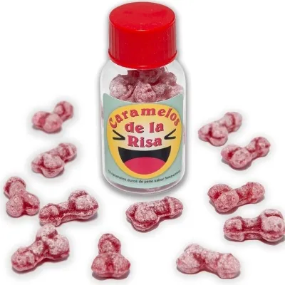 Red candies in the shape of a penis, scattered around a jar with a red lid and the label "Caramelos de la Risa".