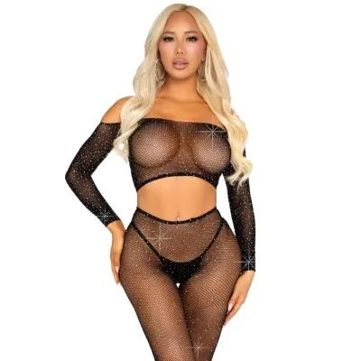 Person in a black, glittery mesh outfit with long sleeves and blond hair, posing in front of a white background.