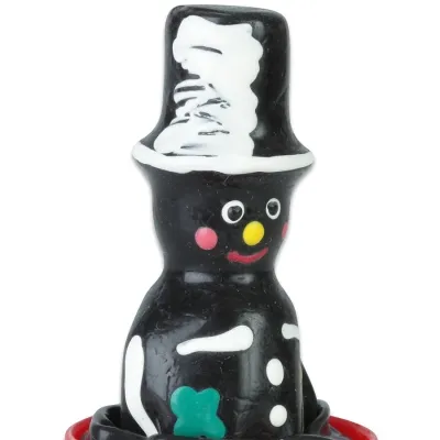 Licorice chimney sweep figurine with top hat, colorful face and green clover on the chest.
