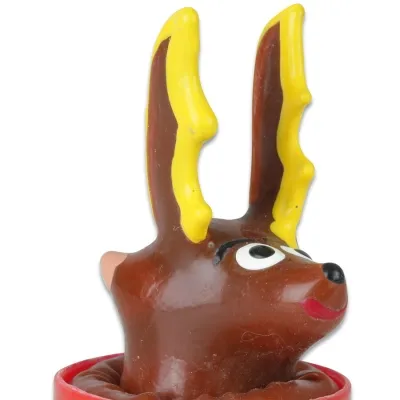 Braune Plastikfigur eines Rentiers mit gelben Geweihen und großen Augen, auf rotem Sockel.