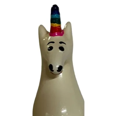 Ceramic unicorn with rainbow horn and friendly facial expression.