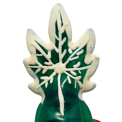 Grünes Blatt mit weißem Schneeflockenmuster aus Zuckerguss verziert.