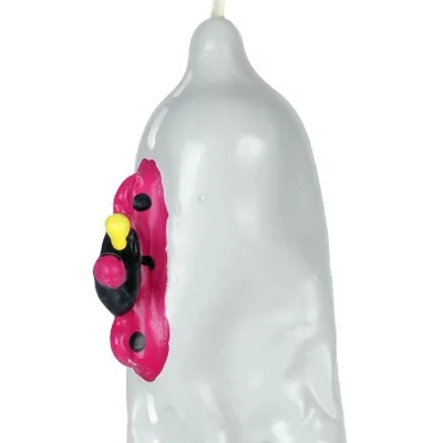 Grey candle with a red and black ladybug design on the side.
