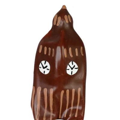 Brown figure with two white, patterned eyes and vertical lines on the body.