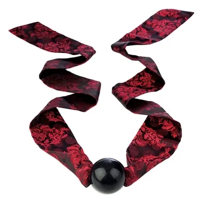 Red patterned ribbon with a black ball in the middle, decoratively draped.