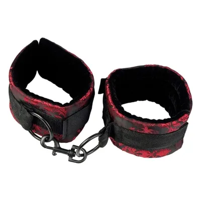 Black and red handcuffs with buckles and hooks, on a white background.