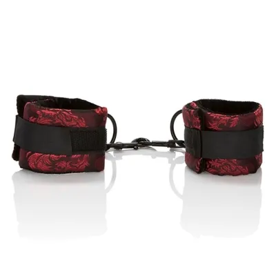 Red and black handcuffs with a floral pattern, connected by a metal hook.