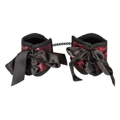 Red and black handcuffs with bows and chain, decoratively designed.