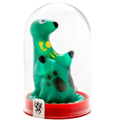 Green, polka-dotted toy in the shape of an animal under a transparent dome with a red base.