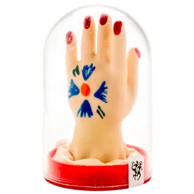 Artistic hand in a glass dome with red nails and a blue drawing on the back of the hand.