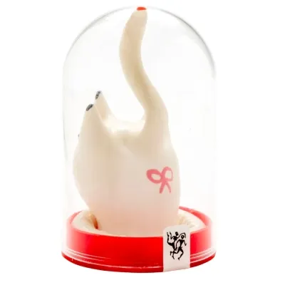 Weiße Katzenfigur mit erhobenem Schwanz in einer durchsichtigen Kuppel, roter Sockel, rosa Schleife auf der Seite.