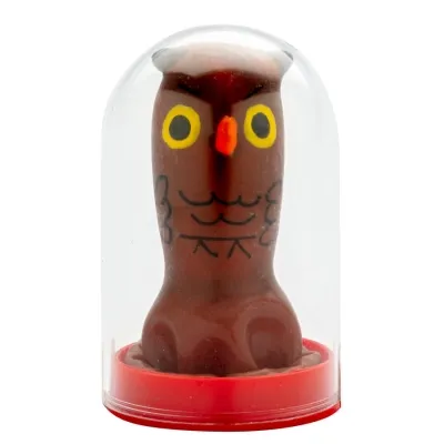 Brown owl figurine with yellow eyes and red beak in a transparent plastic case on a red base.