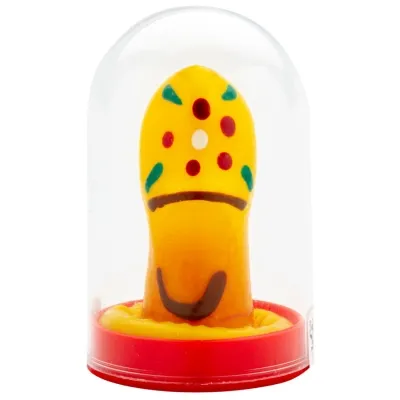 Yellow marzipan pastry in the shape of a mushroom with colorful dots, under a transparent dome on a red base.