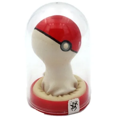 Rote und weiße Figur in einer durchsichtigen Kuppel, die einem Pokéball ähnelt, auf rotem Sockel.