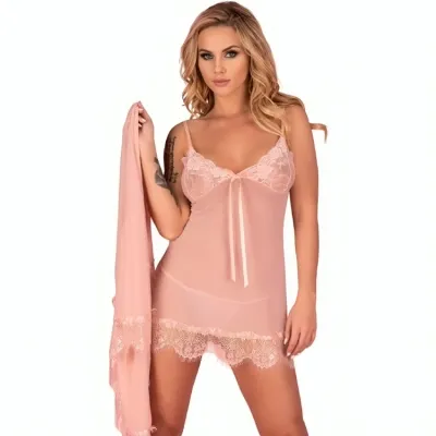 Woman in pink nightgown with lace, holding matching fabric, looks directly into the camera.