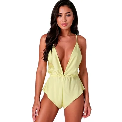 Woman in a yellow, low-cut jumpsuit with spaghetti straps against a white background.