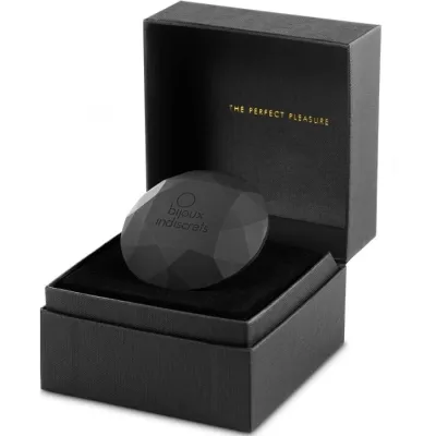 Black, faceted object in an open black box labeled "bijoux indiscrets" and "The Perfect Pleasure".